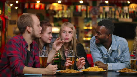 Eine-Große,-Fröhliche-Gruppe-Junger-Leute-In-Der-Bar,-Plaudert,-Diskutiert-über-Das-Semester,-Die-Neuesten-Gerüchte,-Lacht-Und-Trinkt-Bier.-Multiethnische-Gesellschaft.